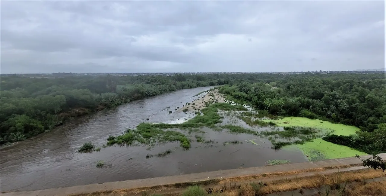 The Santa Ana River swells through a bend outside Norco during downpours caused by Tropical Storm Hilary Sunday afternoon. The west county fared far better than communities In the Coachella Valley. Credit: Photo by Gary Evans