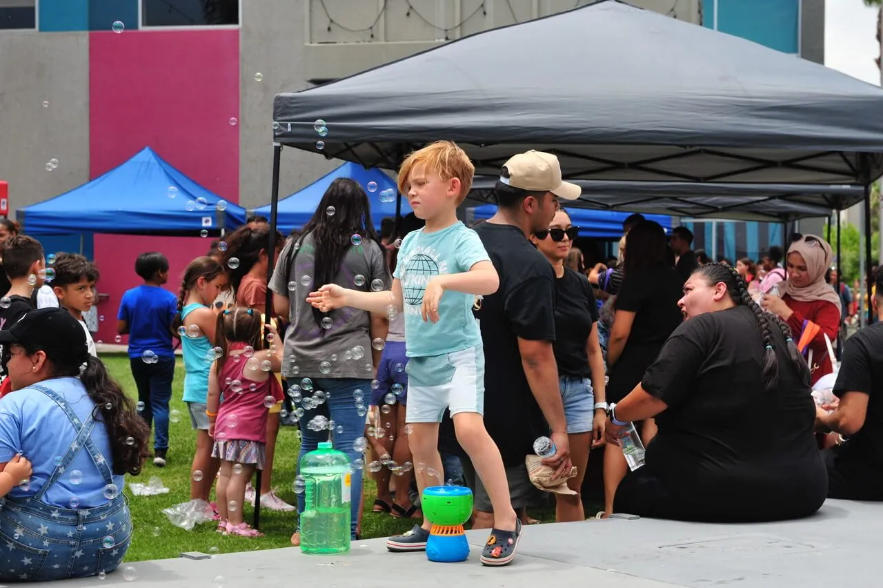 Local Schoolchildren Five-year-old Hayden Hunter is awash in bubbles as one of more than 2-thousand schoolkids who attended the Leela Project Barbers & Backpacks back-to-school event in Corona.