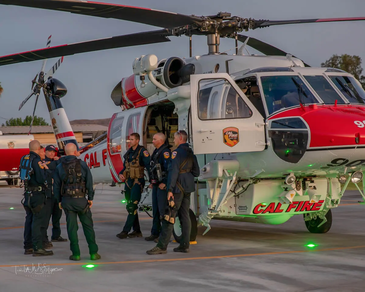 While hovering, FC Rodriguez prepares to lower the hoist rescue hook to the ground during training evolutions, Dec 2022.
Credit: Photo by Ted Schaffer. Tim Rodriguez Eulogized