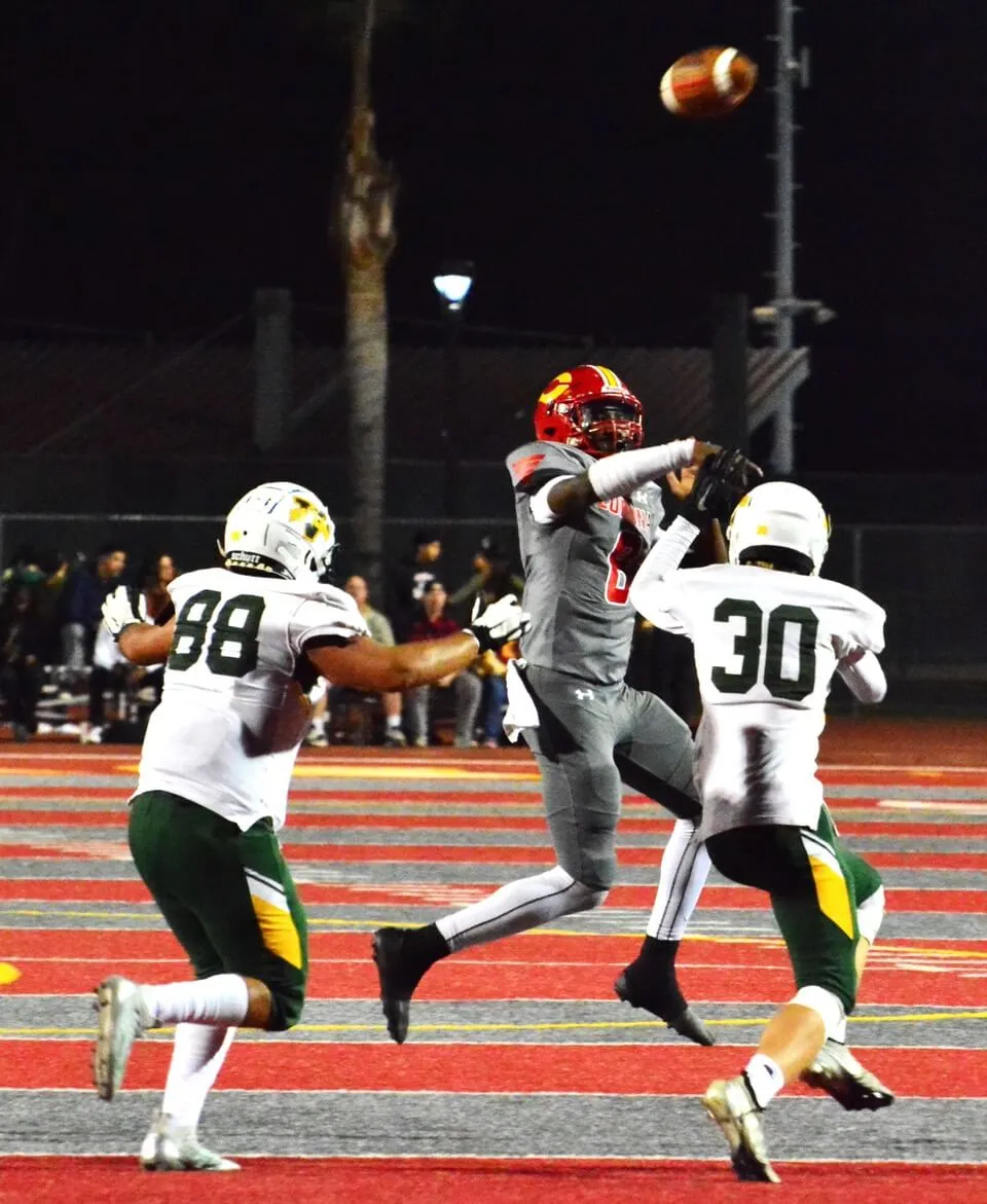 Corona’s Quarterback Ty Owens launches a 40-yard touchdown pass to a wide-open Rocco Scialpi during the Panthers 41 – 14 victory over the Rancho Alamitos Vaqueros. Omar Salazar (88) and Jonathan Biggs (30) are late to the quarterback.
Credit: photo by Gary Evans