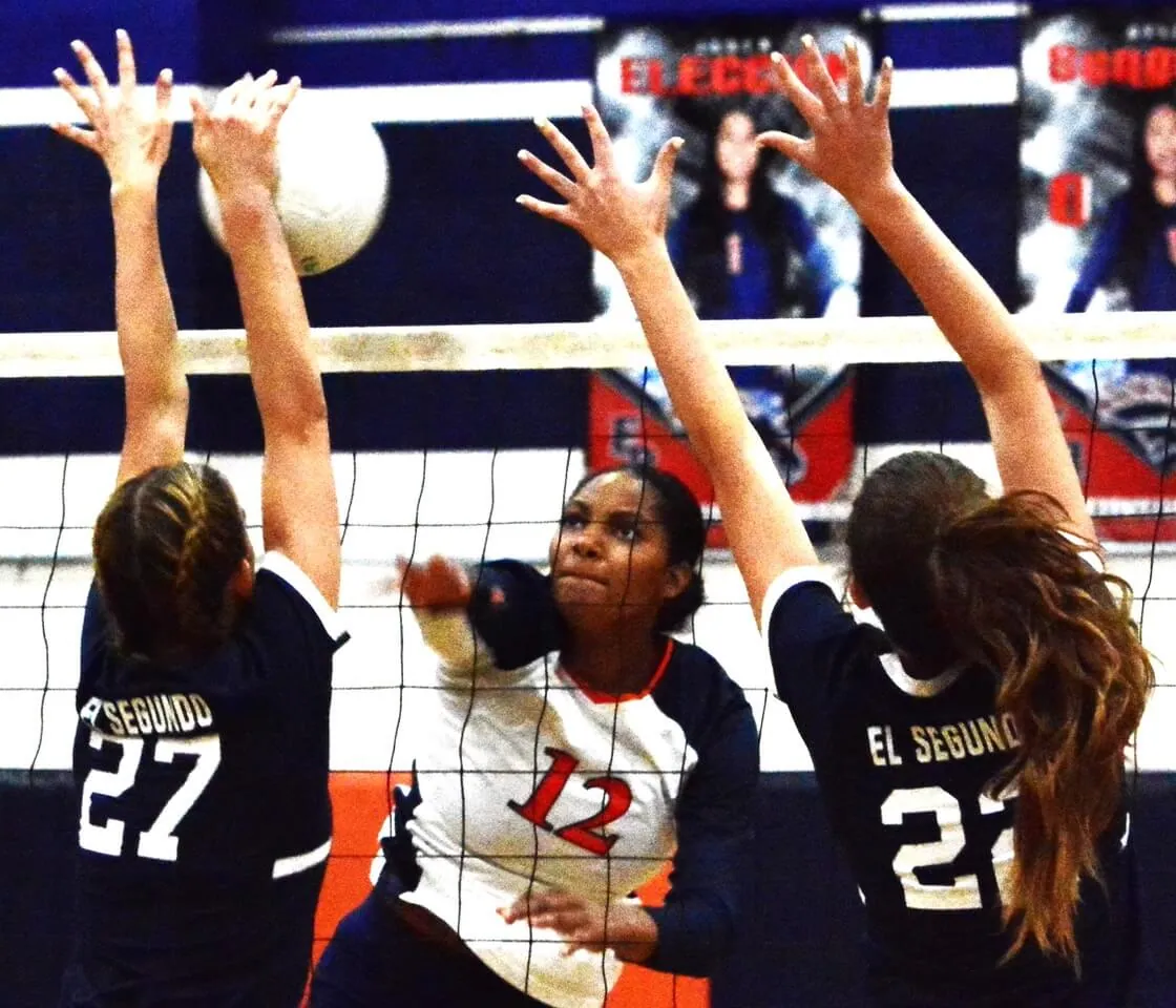 Eastvale Roosevelt’s Milani Lee (12) blasts a shot past El Segundo’s Joslyn McCarthy (27) and Caidee Baird (22).