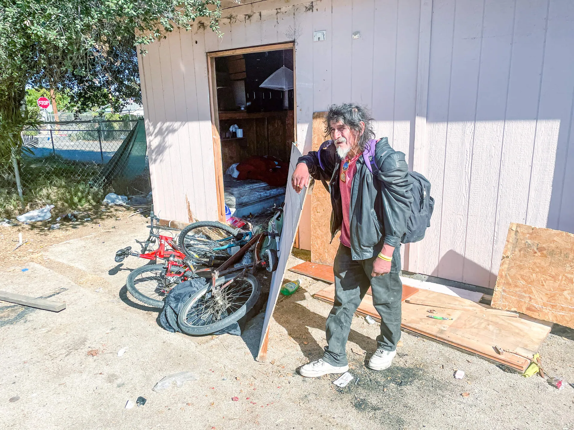 Eddie Cortez visits a friend who looks after his red bicycle when Eddie is on the streets. Credit: Photo by Don Ray