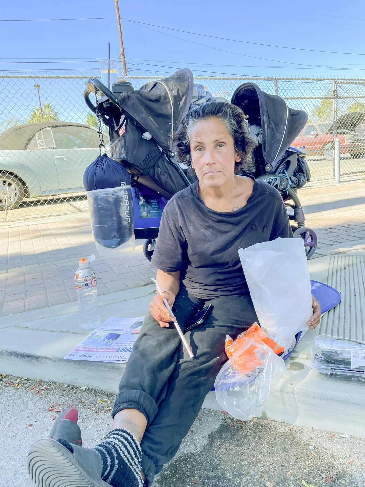 Denise Bustamante graciously accepted a meal from a caring stranger on D Street in Perris. Her new sleeping bag hangs in the background.
Credit: Photo by Don Ray