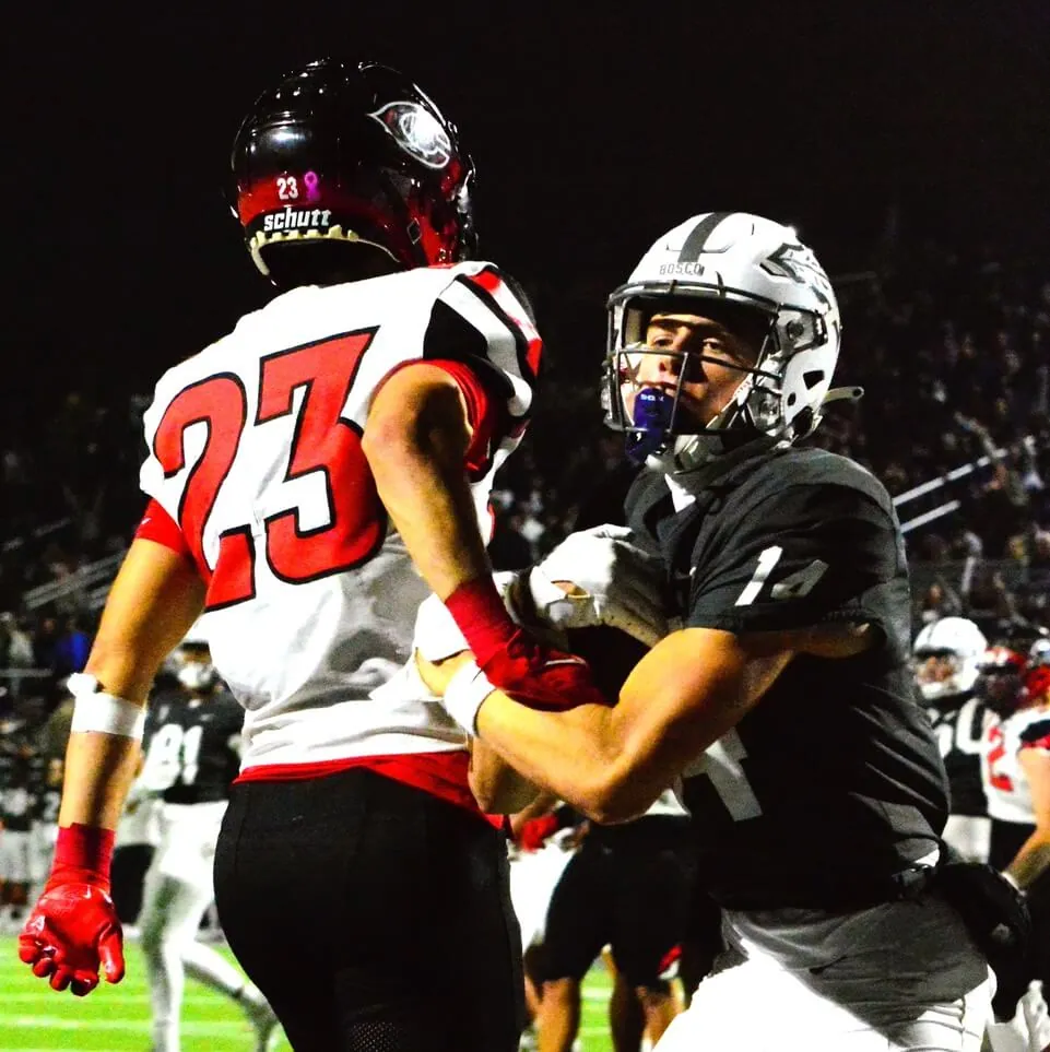 St. John Bosco’s Tommy Maher (14) tightly clutches what proved to be the game winning touchdown with 3:29 remaining, as Corona Centennial’s Cade Paterson (23) defends.