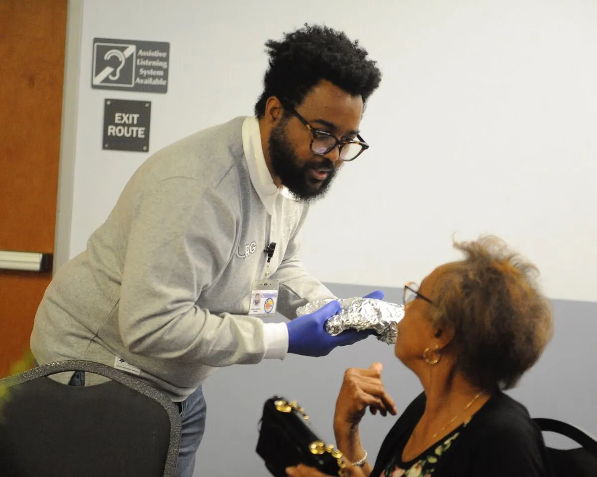 Joshua Smalley, a waiter at the Corona Senior Center Thanksgiving lunch, talks to Margie Zancy, of Corona, at the Circle City Center Wednesday
Credit: Photo by Jerry Soifer