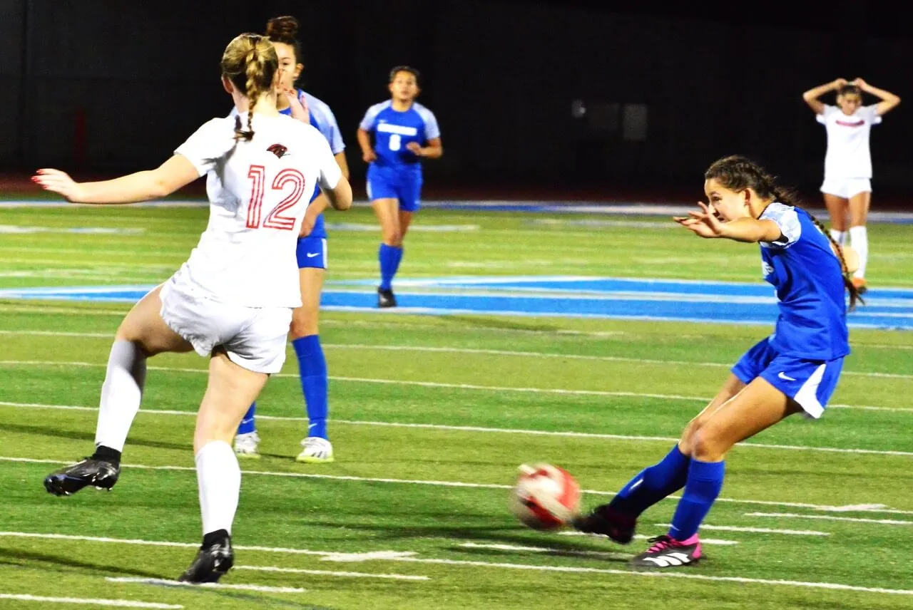 Featured Photos 12-15-2023. Corona Santiago’s Alexis Coughlin (15) battles a Downey player for the ball during the Sharks 5 – 0 throttling of the Vikings.