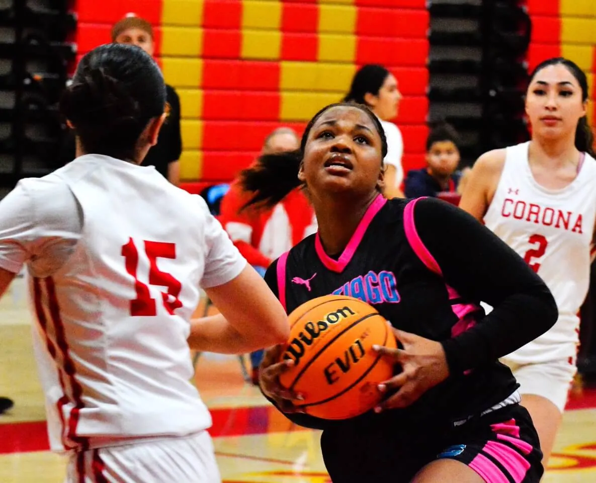 Corona Santiago’s Rylee Ghent (center) drives the lane between Corona Panthers Fia Liaga (15) and Daisy Canchola (2) during the Sharks 60 – 31 victory over the Panthers. Credit: Photo by Gary Evans