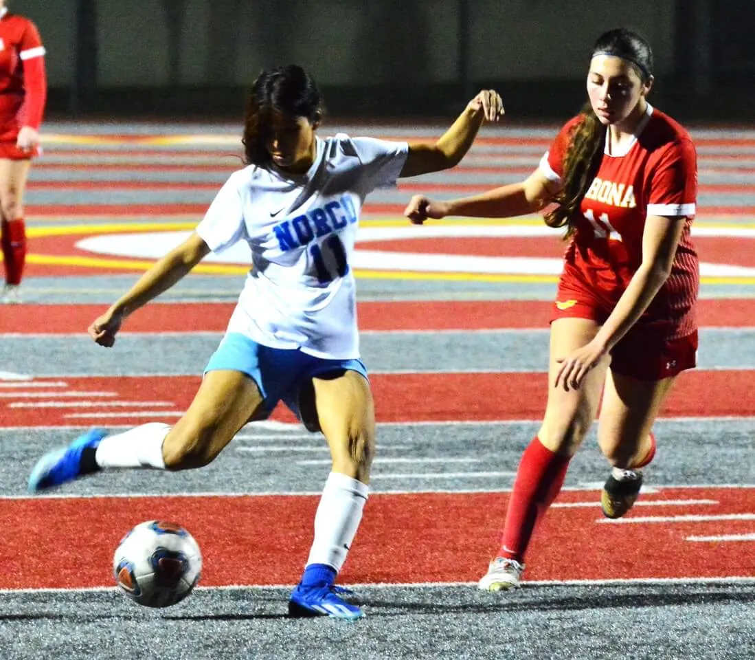 Norco’s Ashlee Bahena (11) takes a shot on goal while Corona’s Vanessa Dias (11) defends. Photo by Gary Evans