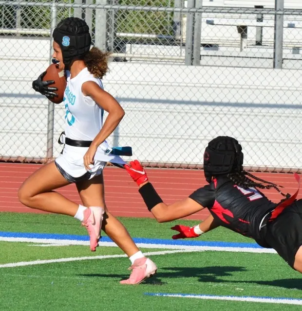 Corona Santiago’s Talan Beyer (left) escapes the grasp of a Centennial defender who grabs the shirt but not the flag as Beyers scores the game-winning touchdown. The Sharks topped the Huskies 12 – 6.
Credit: Photo by Gary Evans