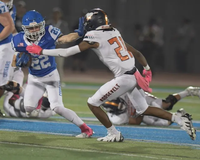 Norco running back Trevor Schneider stiff-arms Roosevelt's Tra'von Flournoy as the Cougars roll to a 49-7 win last Friday. Photo by Jerry Soifer