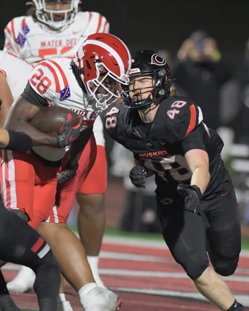 Corona Centennial Huskies. Corona Centennial defender Hayden Zentner comes up to tackle Mater Dei ball carrier Kennie Leggett.