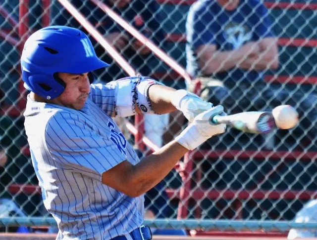 Norco’s Jordan Ayala hits the ball off the end of the bat, which fluttered over third base into left field, allowing Ayala to slide into second with a double against Corona.  
Credit: Photo by Gary Evans
