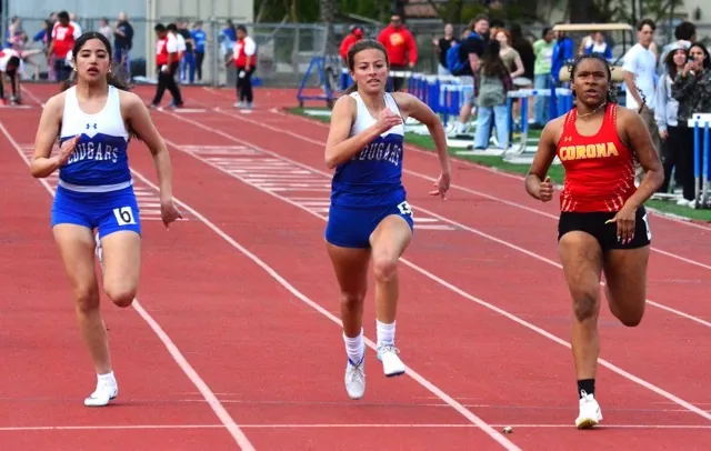 Norco’s Vedali Luna (left) and Makayla Sandoval (center) chase Corona’s Rylee Smith in the girls 100 Meters run.
Credit: Photo by Gary Evans