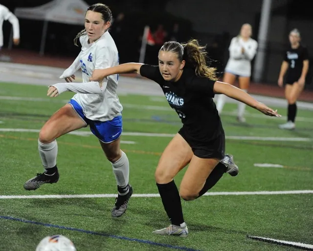 Corona Santiago's Maddy Saruwatari, right, clutches the arm of a Santa Margarita player as they charge after the ball.
Credit: Photo by Jerry Soifer