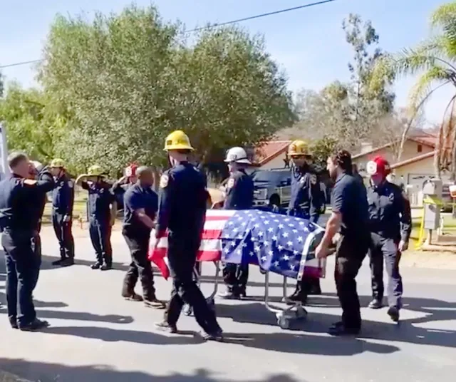 Colleagues and first responders salute the flag draped stretcher bearing the body of murdered Riverside County Fire Captain Rebecca Ramodi, as she is transported from her Ramona home on February 17.