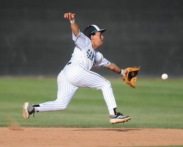Corona Santiago's Mario Cuadros stretches to field a ground ball but his throw was not in time for the out. The Sharks rallied from a 3-0 deficit to defeat Eastvale Roosevelt 5-4, in eight innings.
Credit: Photo by Jerry Soifer
