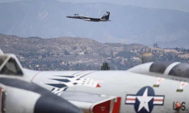 A U.S. Air Force F-15 Eagle takes off over old planes at the March Air Museum.