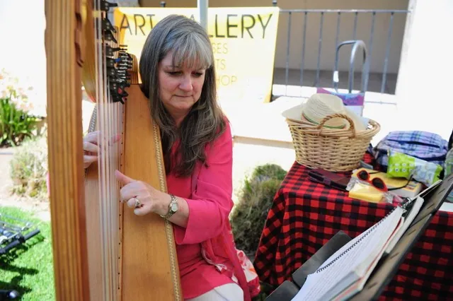 Leslie Berger, of Corona, plays the harp at the arts and music festival Saturday at the historic Corona Civic Center.
Credit: photo by Jerry Soifer