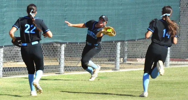 Norco left fielder Tamryn Shorter (center) snags a foul ball for an out while third baseman Sadie Burroughs (22) and shortstop Leighton Gray (14) pursue during the Cougars 6 – 1 CIF Division 1 semi-final victory over Chino Hills Ayala. The Cougars play Orange El Modena for the championship at Deanna Manning Stadium in Irvine, California, on Saturday at 7 pm.
