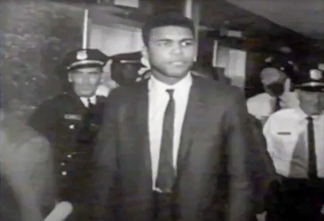 June 20 . Photo: AliCourtHouse Caption: Muhammad Ali Leaves the Courtroom in Houston, TX after being sentenced to 5 years in prison for evading the draft during the Vietnam War.