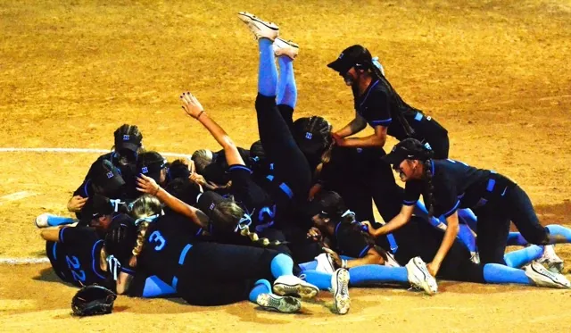 Norco’s Dakota Potter (42 center) rolls down the team pile as the Cougars celebrate winning the 2025 CIF Division 1 CIF Girls Softball championship over El Modena of Orange 3 – 0.