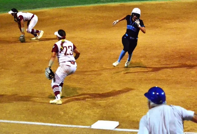 Norco’s Sadie Burroughs (center) digs for third and is being waved home by Coach Rick Robinson while El Modena shortstop Kylie Tafua (left) and third baseman Monica Garcia watch Savannah Gonzalez’s base hit go to left.