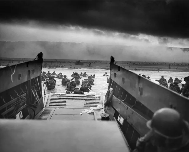 A LCVP (Landing Craft, Vehicle, Personnel) from the U.S. Coast Guard-manned USS Samuel Chase disembarks troops of Company A, 16th Infantry, 1st Infantry Division (the Big Red One) wading onto the Fox Green section of Omaha Beach (Calvados, Basse-Normandie, France) on the morning of June 6, 1944. American soldiers encountered the newly formed German 352nd Division when landing. During the initial landing two-thirds of Company E became casualties.
Credit: Chief Photographer's Mate (CPHoM) Robert F. Sargent