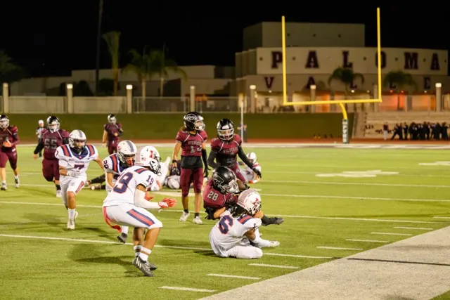 Wildcats RB Dallas Gualco (28) is tackled by Patriots CB Shane Briggs (6).