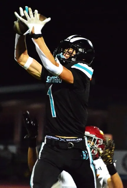 Santiago’s Ryan Wilson (1) snags a pass from quarterback Clayton Plewe in front of Hillcrest defender Dylan Bailey.