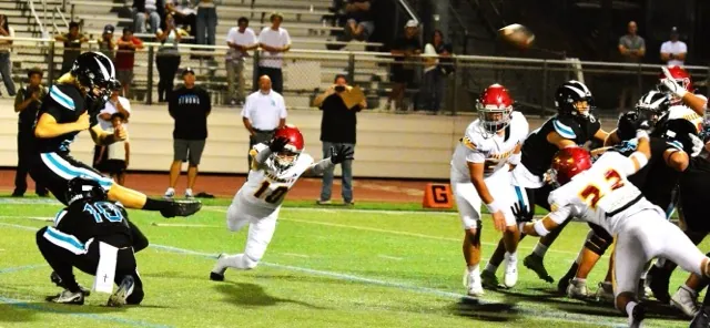 Santiago kicker Carter Tiedt (left) off the hold of Jake Wilson (10) boots the game winning field goal over Hillcrest as time expired. Trojan defenders Chase Ruehl (10), Camren Stuebner (50) and Angel Maldonado (22) attempt the block. In an instant classic, the Sharks and Trojans traded scores, leads, and big plays. Santiago won 52 – 50.