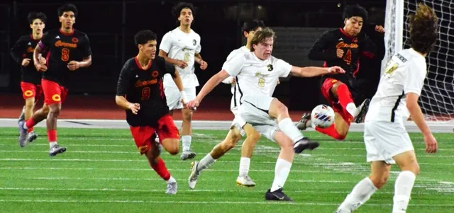 Corona’s Owen Keen (far left), Miguel Rocha Garcia (8), Julian Sanchez (9) watch a Canyon player and teammate Edwin Carbajal (4) leap for the ball during the CIF Division 1 playoff game. The top-ranked Canyon Comanches scored the game’s lone goal, eight minutes into overtime.