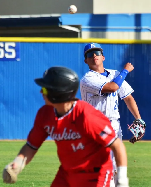 Norco’s Zion Martinez (top) snagged an ankle high line drive for an out, and throws to first to double up Centennial runner Michael Nonis (14). The Cougars defeated the Huskies 8 – 4.