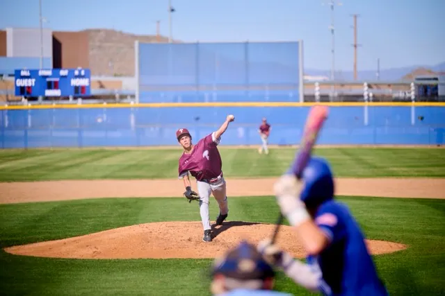 Wildcats #14 Ryder Bland pitches to Bison #5 Dylan Oltjenbruns whose hand creeps up the bat to bunt...