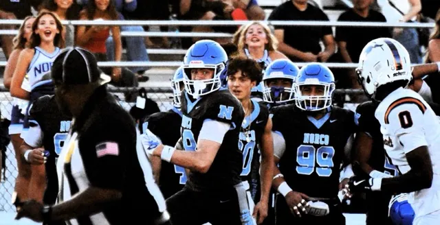 Norco receiver Tegan Ogas (center) eyes Eastvale Roosevelt defender Xavier Marshall (0) after making an incredible one-handed catch and run for a long gain in the first quarter.