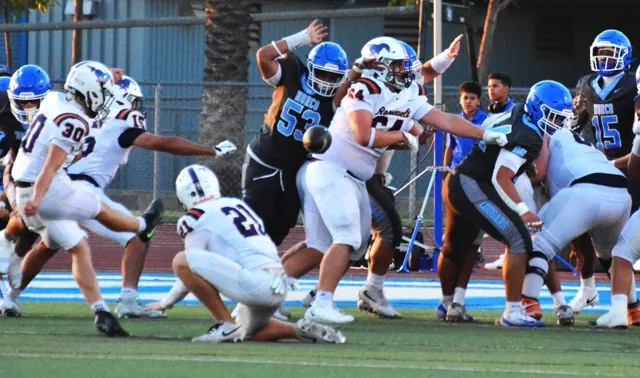 Eastvale Roosevelt’s Kaden Lovell (30) boots the extra point to tie the game at seven in the first quarter while Kaden Wayne (21) holds. Norco’s Justin Suliafu (53) tries to block the PAT while Derek DeSeife (64) blocks and Henderson Carter V (15) looks on