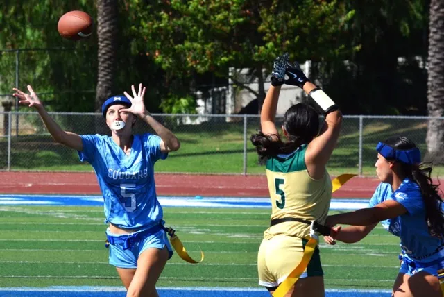 Norco’s Hayden Bolle (5) eyes an interception that bounced off Lakeside receiver Karina Hernandez (5). Bolle grabbed the deflection and ran it back for a pick 6 helping the Cougars blank the Lancers 41 – 0.