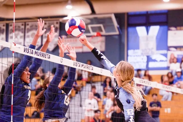 Liberty High School’s #1, Catalina Loven, attempts a spike over the net as two Vista Murrieta players defend