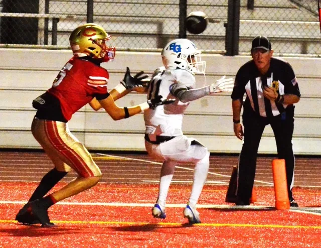 Corona’s Nico Mejia (5) gets ready to catch a touchdown pass after San Gorgonio defender Aaden Rojas (11) deflected the toss right to Mejia under the watchful eye of the referee. The Panthers blanked the Spartans 49 – 0.