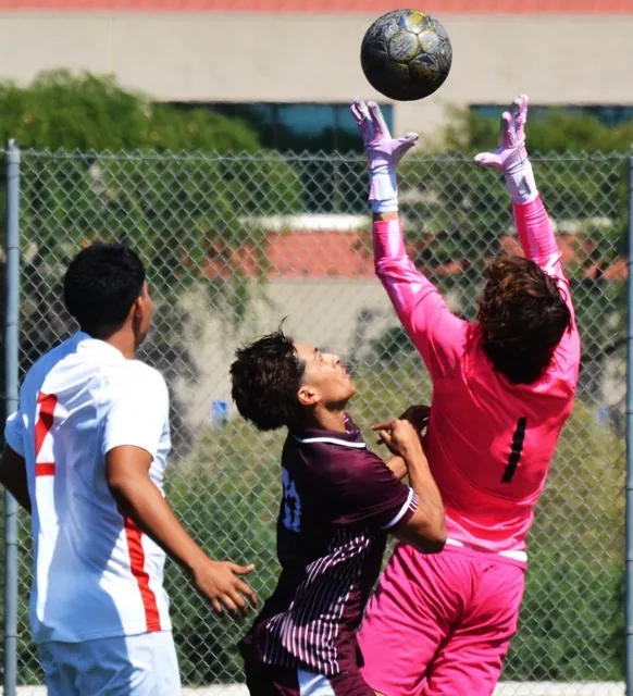 Norco’s Diego Alcaraz (27) pushes Long Beach goalie Fabio Ardizzoia (1) while fighting for the ball, as Nikolas Huebel (2) watches.  The Mustangs beat the Vikings 2 - 1.