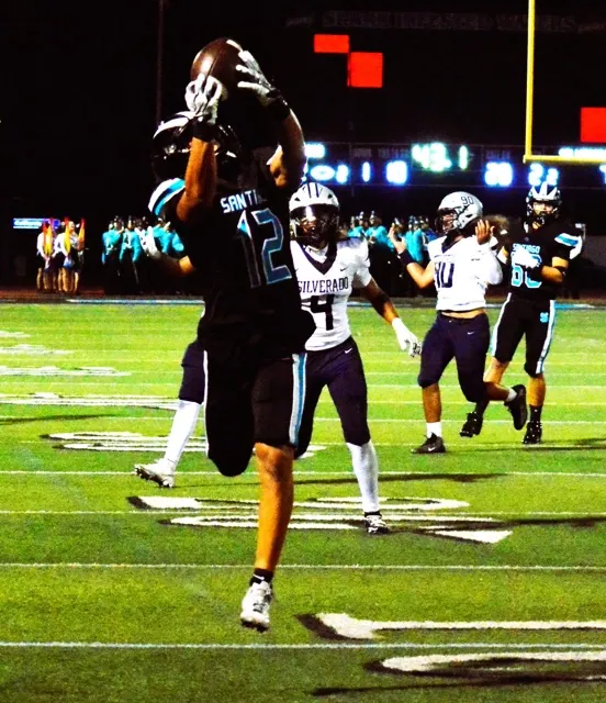 Santiago’s Carter Ward (12) hauls in the second of two 2nd- quarter touchdown passes from QB Jake Wilson for the Sharks in their 26 – 14 win over Silverado. 