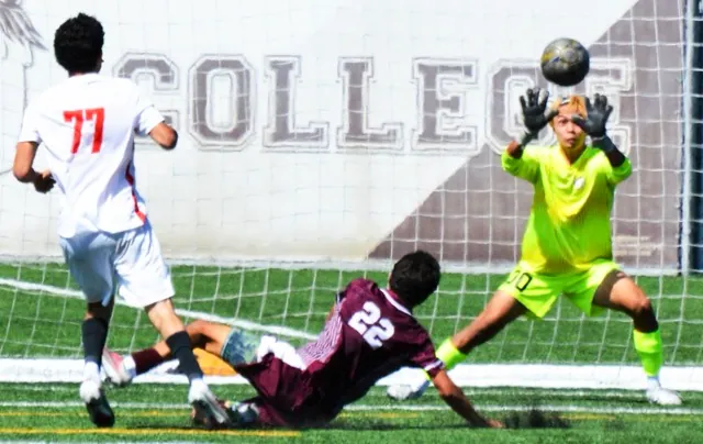 Long Beach’s Steven Sorto (77) blasts a shot on goal as Norco’s James Solek (22) slides to block it and goalie Kaisei Nakamura (00) is ready to deflect the volley.  