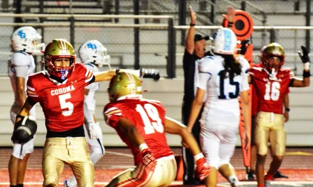 Corona’s Nico Mejia (5) gets ready to celebrate his touchdown catch with Giovanni Gutierrez (19) after San Gorgonio defender Aaden Rojas (11) deflected the toss right to Mejia. Dominic Pickens (16) and the referee signal touchdown while the defenders are stunned by the result.