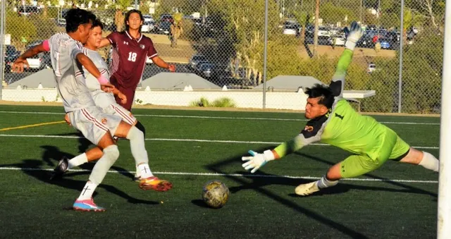 Norco College forward Anthony Alvarez (18) threads the needle with his shot between two defenders and the Victor Valley goalie Leonardo Corona, just missing a score during the Mustangs 3 -1 victory.
Cred: Photo by Gary Evans