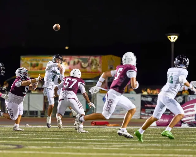 Perris’s Quarterback Corbin Kemp (#1)manages to get the pass off with a Paloma Valley Neeko Scott (#57) closing in.